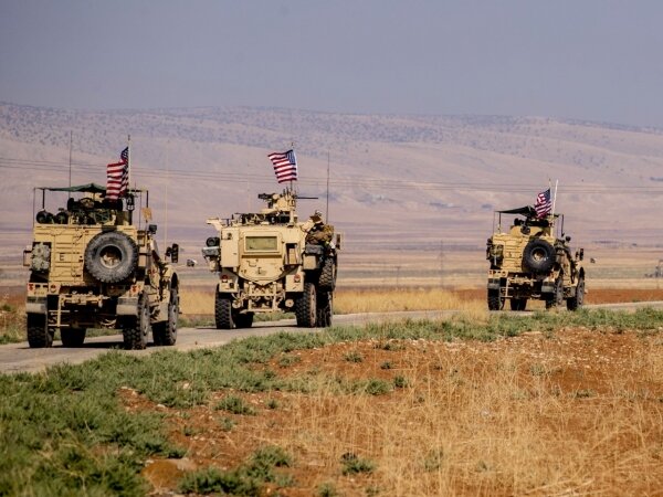 A caravan of U.S. reinforced vehicles watches the northeastern town of Qahtaniyah, Syria.